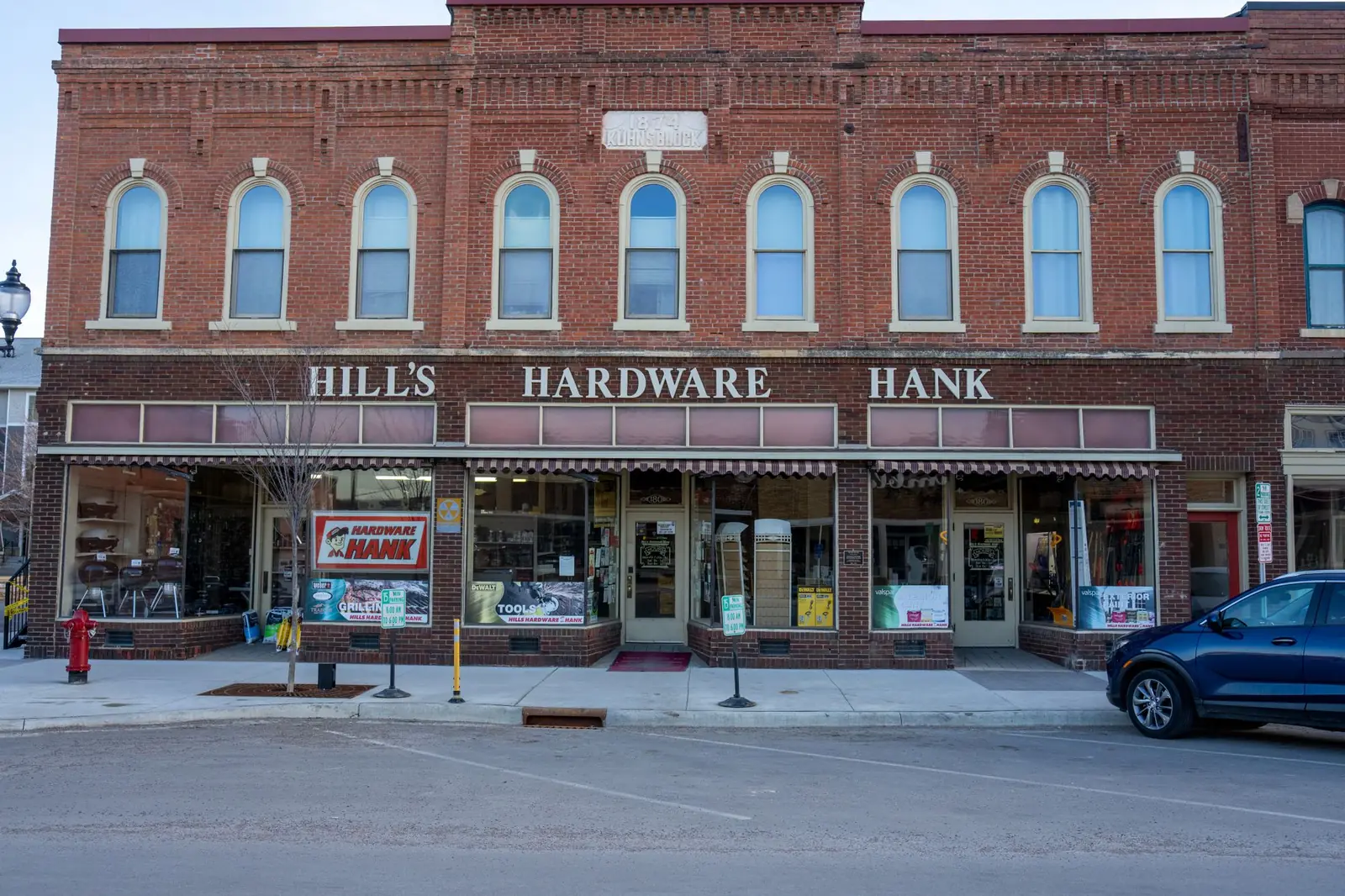 Independent American hardware store with the owner's name across the front of its own brick building