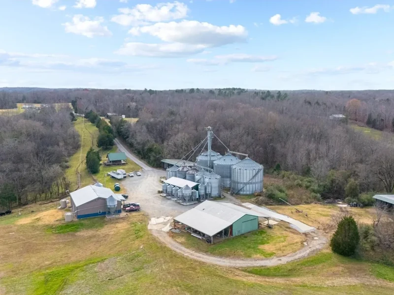 Aerial view of Duck It Farm in Hickman County, Tennessee: the mill, grain bins and outbuildings set in a wooded valley